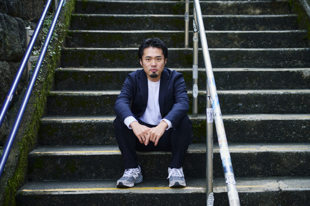 階段に座るJYM橋本